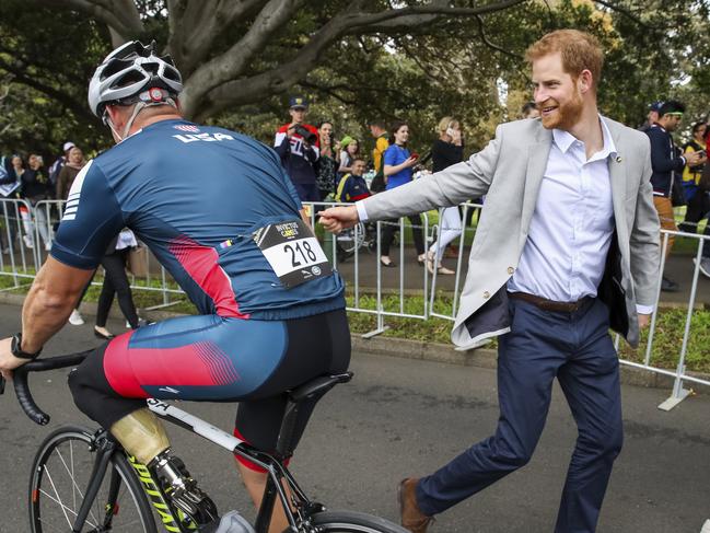 Prince Harry, right, greets a competitor during a cycle race at the Invictus Games. Picture: AP