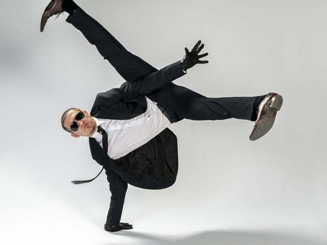 breakdancing businessman performing single handstand looking cool at the camera with sunglasses on, white background. Studioshot. dancing, generic, funny