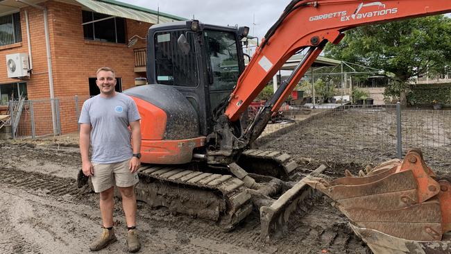 Ryan Garbett goes house to house in Condong with his bobcat. Picture: Liana Walker