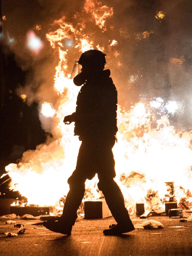 A police officer in riot gear walks past a fire on Interstate 85 during protests in Charlotte, North Carolina. Picture: Getty