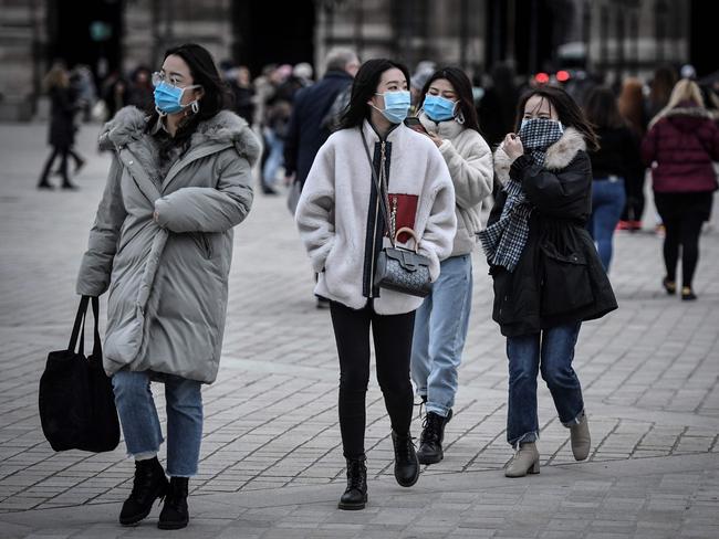 Tourists wearing face masks outside the Louvre in Paris. Picture: AFP