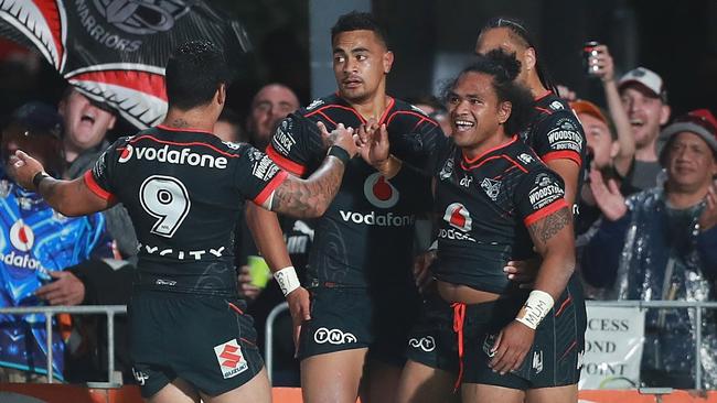 Warriors players celebrate their opening try against the Cowboys on Saturday night. Photo: David Rowland