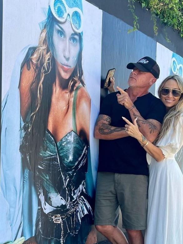 Tish Cyrus posing with now husband Dominic Purcell in front of a poster advertising daughter Miley’s new single. Picture: Instagram