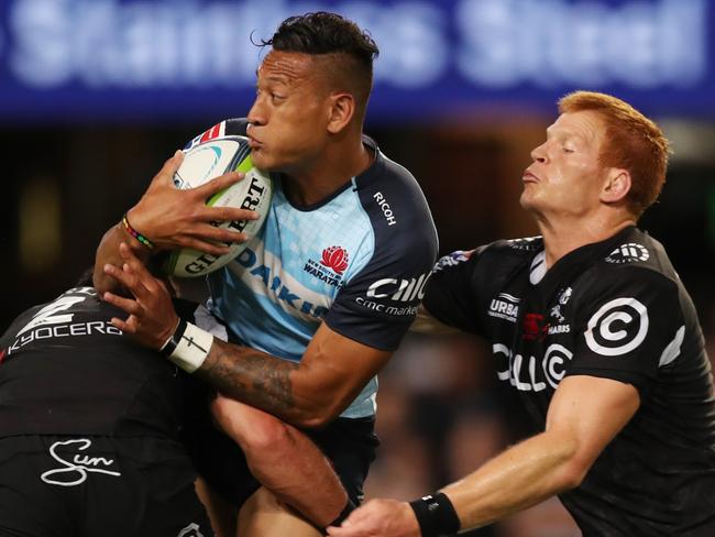 Folau is crunched by a couple of Sharks.