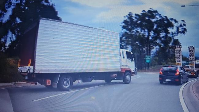 The truck is seen driving across a solid white line on the roundabout.