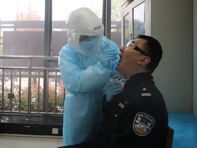 A medical worker takes a swab in Wuhan, China. Picture: AFP