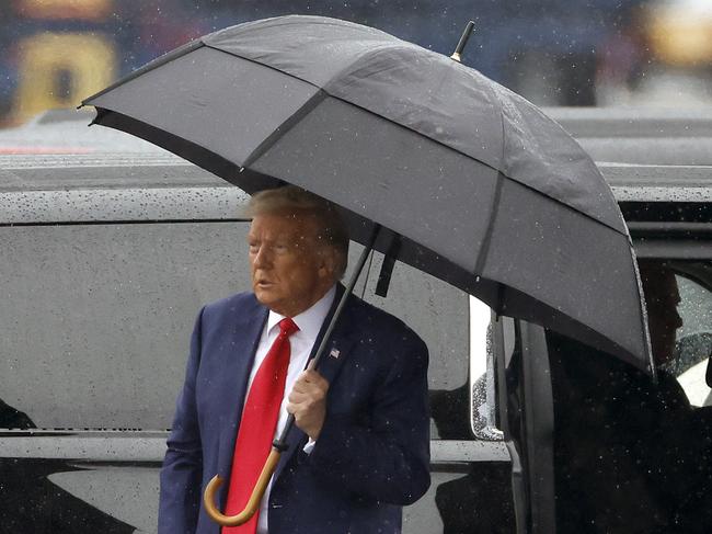 Former US President Donald Trump holds an umbrella as he arrives at Reagan National Airport following an arraignment in a Washington, D.C. court in Arlington, Virginia. Picture: Getty Images/AFP