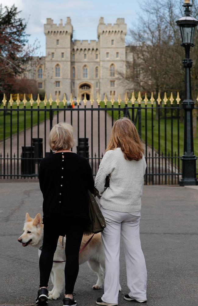 Two women pause at Windsor Castle after the Duke died peacefully on Friday morning. Picture: Adrian DENNIS / AFP