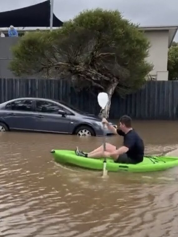 Man canoeing in Safety Beach floodwaters. Picture: Paul Dowsley