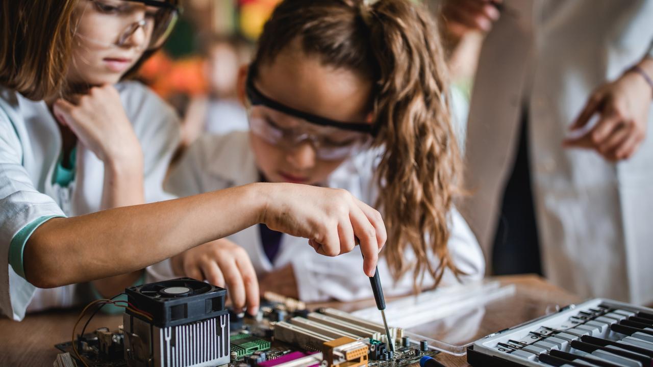 Girls repairing a motherboard in the classroom. Women are still under-represented in STEM careers.
