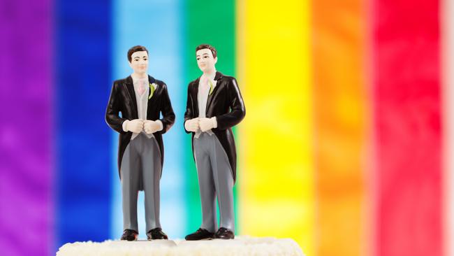 Same sex marriage wedding cake with two male groom figurine cake toppers.