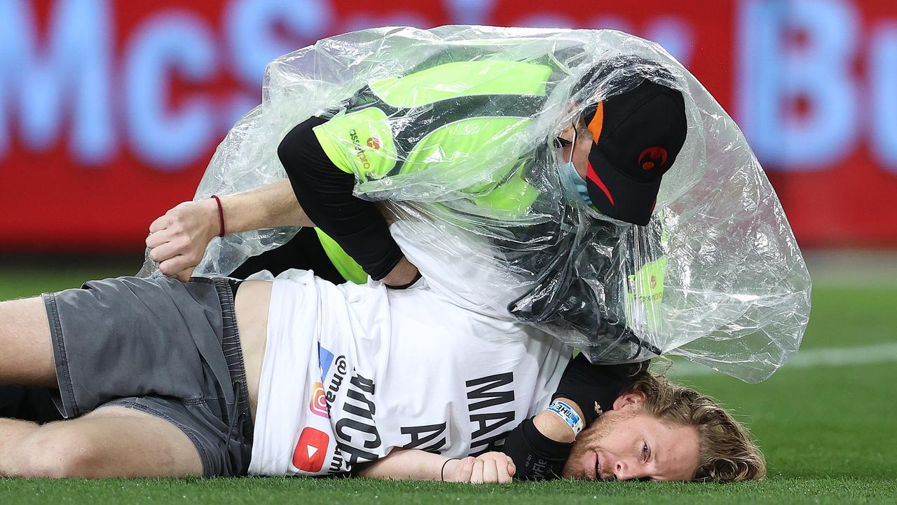One of the pitch invaders is tackled during the Grand Final. Picture: Michael Klein