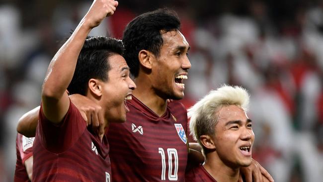 Thailand's midfielder Thitiphan Puangjan (L) celebrates his goal with teammates Thailand's forward Teerasil Dangda, amd Thailand's midfielder Chanathip Songkrasin (R) during the 2019 AFC Asian Cup group A football match between the United Arab Emirates and Thailand at the Hazza bin Zayed Stadium in Al-Ain on January 14, 2019. (Photo by Khaled DESOUKI / AFP)