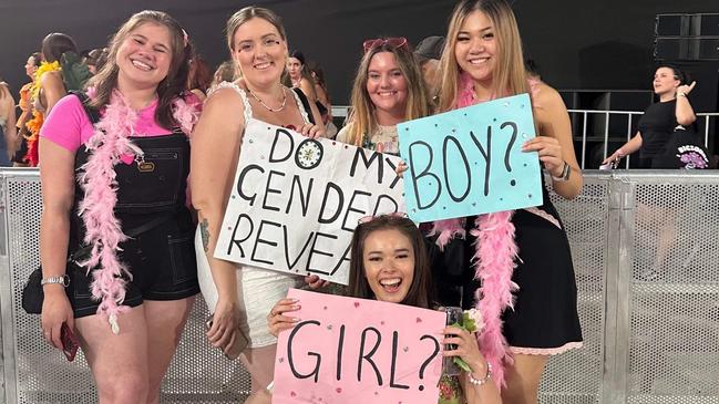 Gina Cunningham, in white, alongside friend Gemma Salvestro and other fans at the Harry Styles concert in Sydney. The group held up their signs, grabbing Styles’ attention among 70,000 fans. Supplied by Gina Cunningham