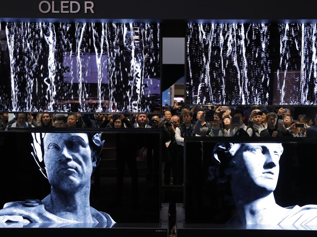 People take pictures of a display of LG Signature OLED R TVs at the LG booth during the CES tech show in Las Vegas. Picture: John Locher