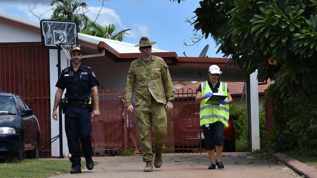 A police officer, ADF member and public health environmental officer conduct compliance checks at a NT residence. Four people have been handed fines for flouting quarantine requirements in recent days. Picture: Will Zwar