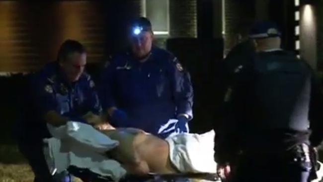 The man is treated by paramedics after being arrested. Picture: Seven News