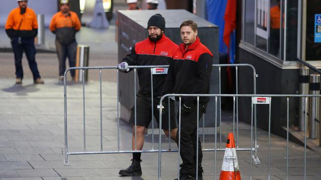 Construction workers move fencing into position. Homeless relocation in Martin Place on June 24, 2017 in Sydney, Australia. Picture: Jason McCawley.