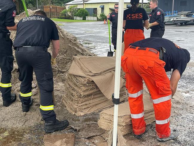 Emergency service workers filling sandbags.