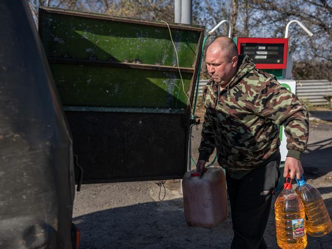 A man loads his vehicle with jerry cans after Russian attacks cause widespread blackouts. Picture: Carl Court/Getty Images