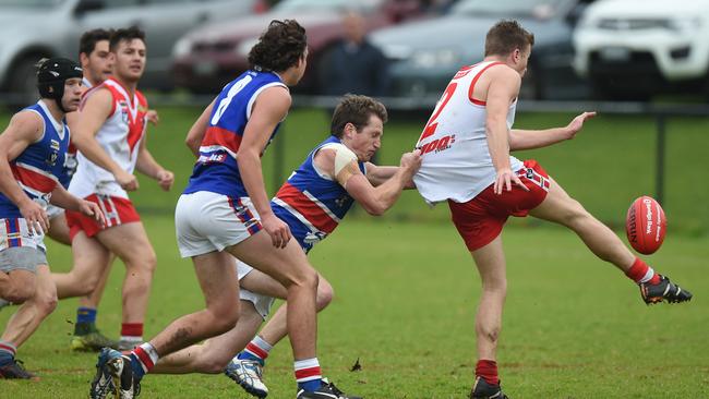 Karingal’s Tom Wilkinson gets a kick away under pressure against Mornington. Picture: Chris Eastman