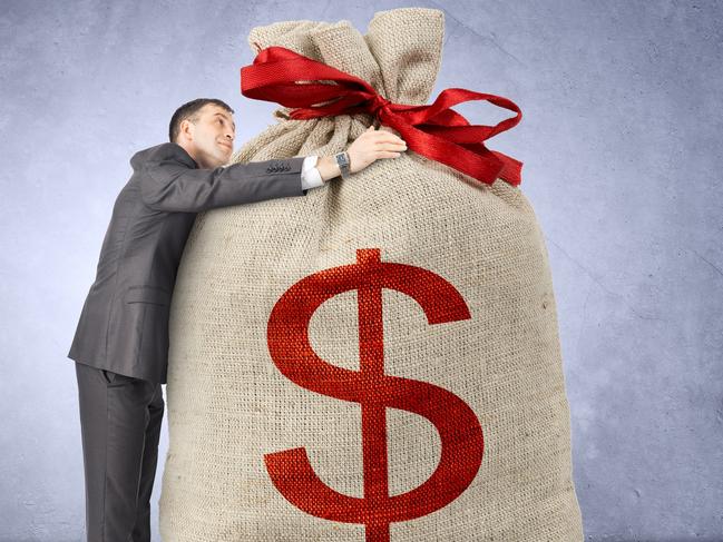 Businessman hugging bag with dollar sign on grey wall background; rich wealthy generic money