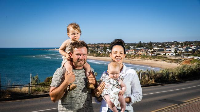 Jordan Colquhoun and Paige Harkness and daughters River and Bowie near the Christies Beach home they have just sold. Picture: Tom Huntley