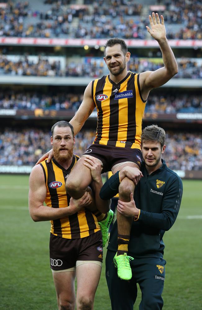 Luke Hodge is chaired off from the MCG by Jarryd Roughead and Grant Birchall after his 300th game. Pic: Michael Klein