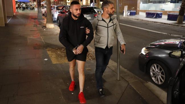 Percival (left), 24, is led away by Detective Sergeant Matthew Crematy after allegedly being caught with 25 bags of cocaine and $2360 in cash. Picture: Jonathan Ng