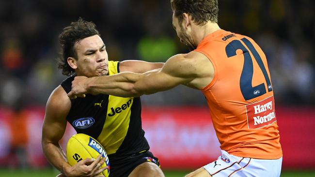 Daniel Rioli of the Tigers fends off a tackle by Matt Buntine of the Giants.