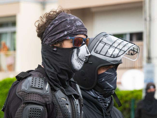 Masked locals keep an eye on activists at the entrance to Tuband in Noumea. Picture: AFP