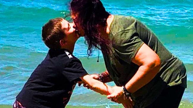 Jai Warner, who is non verbal, takes a dip with his mum at Straddie in the safety of a swimming enclosure. Pictures: Contributed