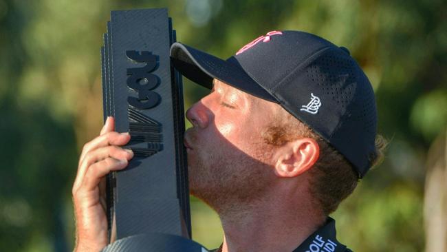 Talor Gooch of the US kisses the trophy after winning the 2023 Liv Golf tournament (Photo by Brenton Edwards / AFP)