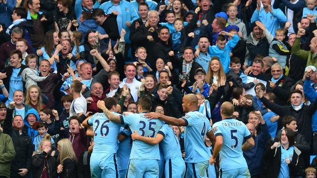 Manchester City players celebrate with the crowd.