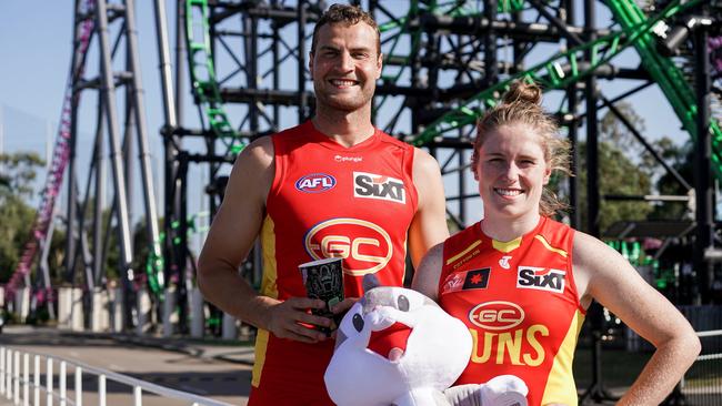 AFL players Jarrod Witts and Tara Bohanna of the Gold Coast Suns in front of a rollercoaster as the team signs Sixt as a new sponsor. Picture: Supplied