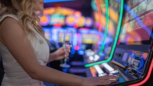 A woman plays a pokies machine. Picture: istock