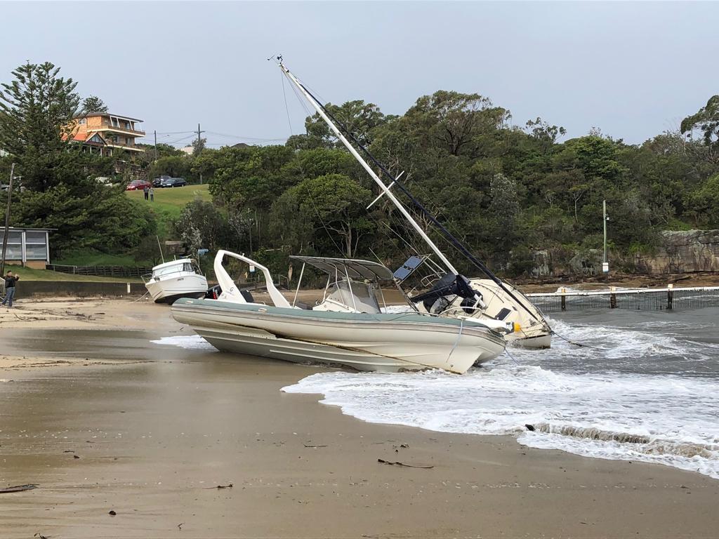 Boats wash onto the sand at Little Manly. Picture: Jim O'Rourke.