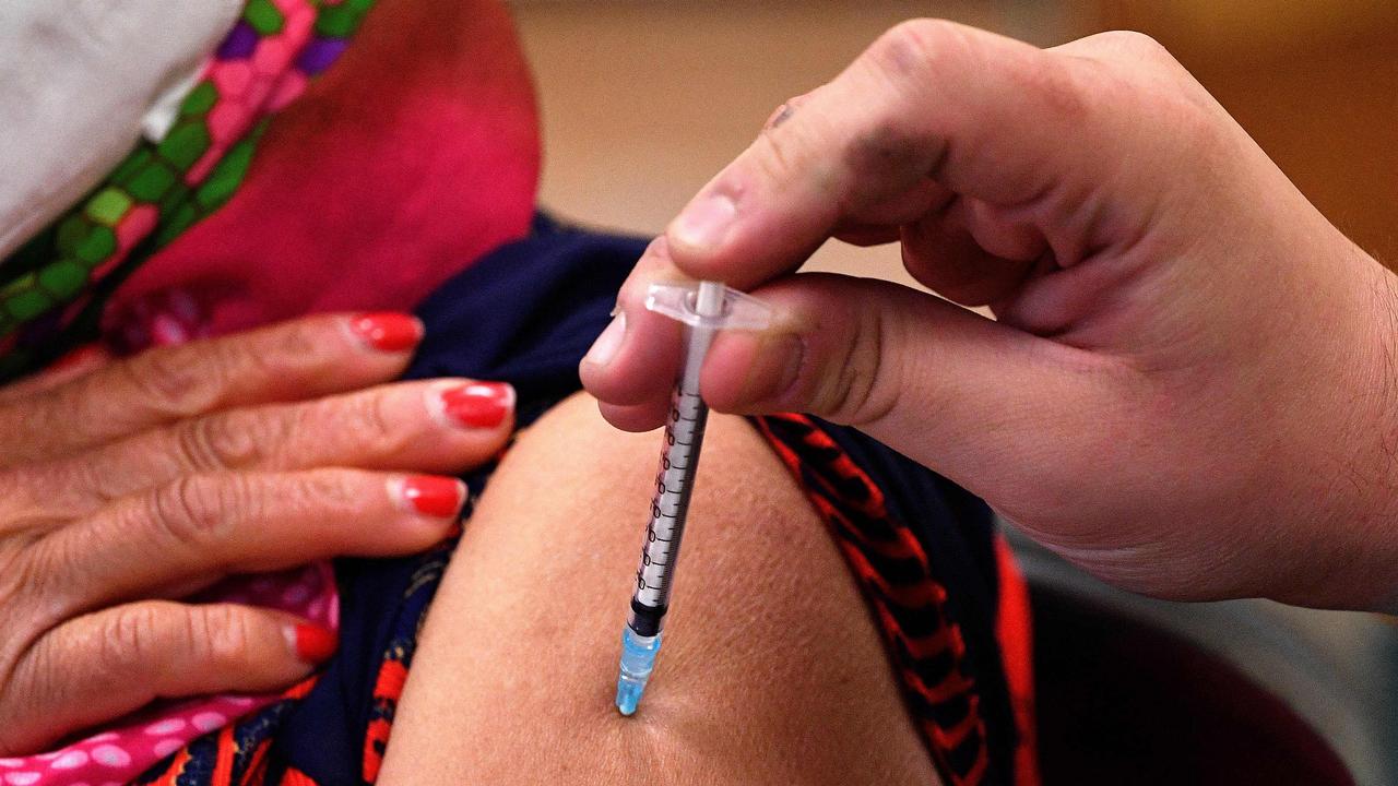 A woman gets her first dose of AstraZeneca vaccine at a walk-in COVID-19 clinic inside a Buddhist temple in the Smithfield suburb of Sydney.