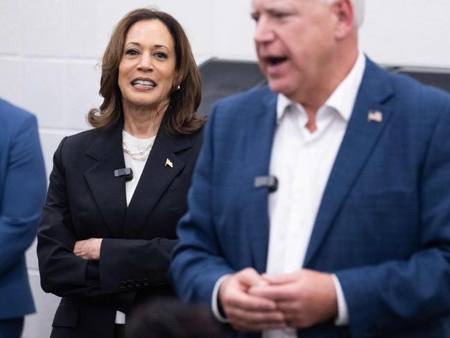 Democratic presidential candidate US Vice President Kamala Harris listen to her running mate, Governor Tim Walz, speak during a visit with members of the marching band at Liberty County High School in Hinesville, Georgia, August 28, 2024, as they travel across Georgia for a 2-day campaign bus tour. (Photo by SAUL LOEB / AFP)