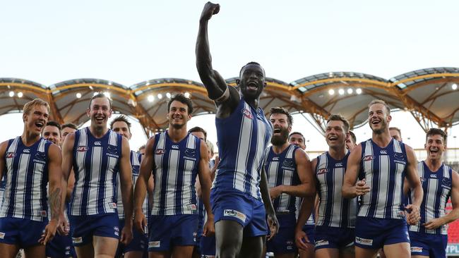 A triumphant Majak Daw leads his North Melbourne teammates off Metricon Stadium. Picture: Michael Klein