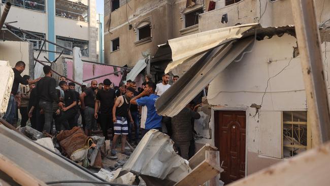 Palestinians search for casualties in the rubble of a house destroyed in an Israeli strike in the centre of Rafah. Picture: AFP.