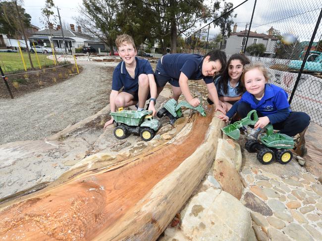 Kew Primary School students Sam (year 6), Ted (year 1), Sophie (year 6) and Maddie (year 1) enjoy their revamped playground. Picture: Tony Gough