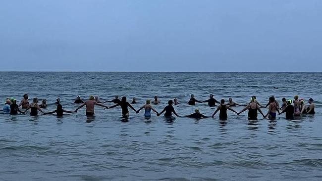 A swimming group in Torquay pay tribute to Vic Verecondi at the main beach.