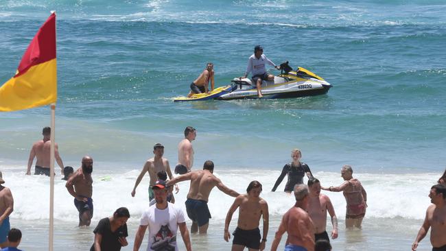 Lifeguards at Surfers Paradise beach keep an eye on beachgoers and keep them swimming between the flags on one of the busiest days of the year. Picture: Glenn Hampson