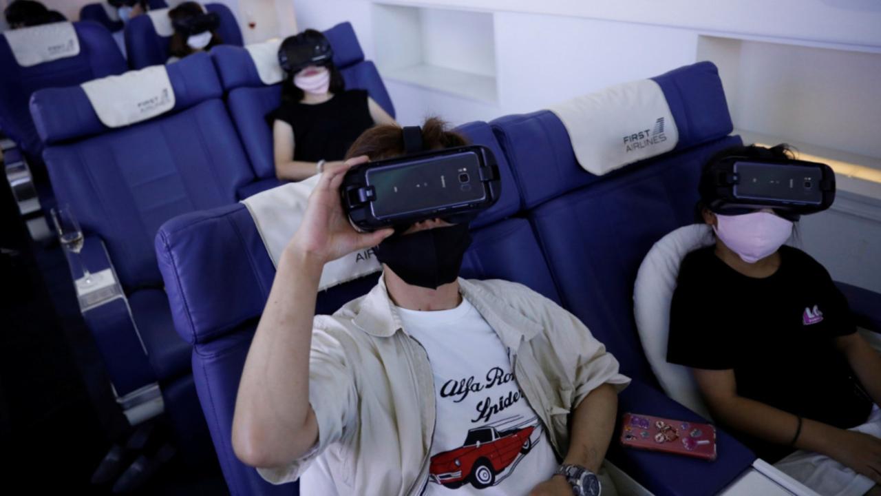Customers in flight seats use virtual reality (VR) devices at First Airlines, that provides VR flight experiences, including 360-degree tours of cities and meals, amid the COVID-19 pandemic in Tokyo, Japan.Reuters