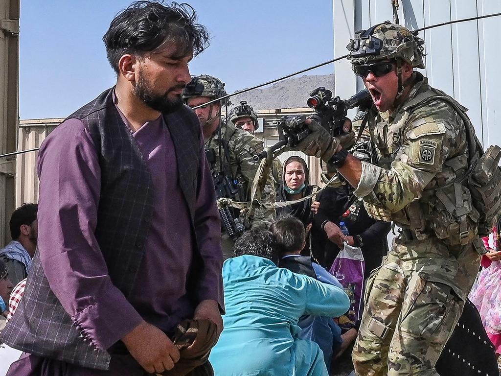 A US soldier points his gun towards an Afghan passenger Kabul Airport. Picture: Wakil Kohsar/AFP