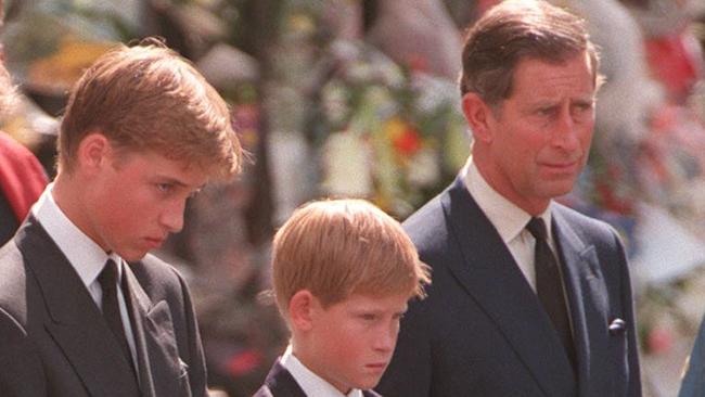 Prince Charles with Prince William and Prince Harry watch the hearse as it leaves Westminster Abbey.