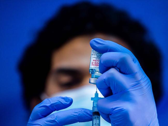 (FILES) In this file photo taken on February 16, 2021 medical worker Robert Gilbertson loads a syringe with the Moderna Covid-19 vaccine to be administered by nurses at a vaccination site at Kedren Community Health Center, in South Central Los Angeles, California. - US pharmaceutical firm Moderna said on April 29, 2021 it expects to increase global production of its Covid-19 vaccine to up to three billion doses in 2022. The company said in a statement that it would make new funding commitments to increase supply at its manufacturing facilities. (Photo by Apu GOMES / AFP)