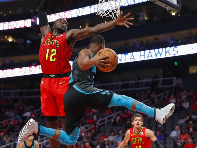 Charlotte Hornets guard Kemba Walker passes as Atlanta Hawk Taurean Prince defends.