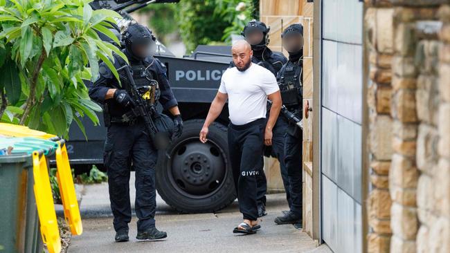 Police escort crime figure Omar Haouchar during a raid on his home in Drummoyne in December, 2023. Picture: Max Mason-Hubers